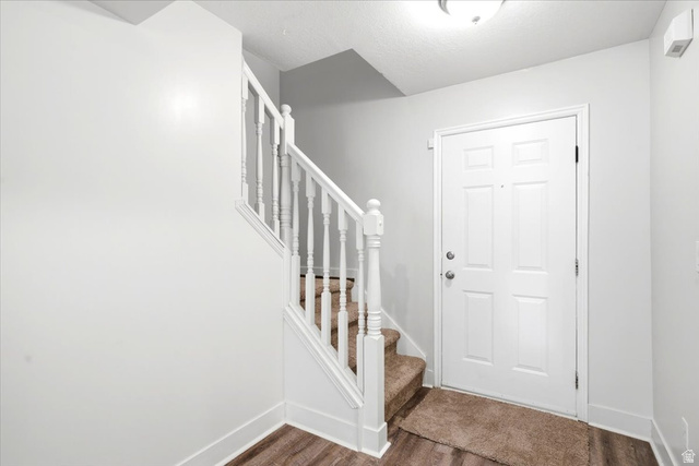449 West 200 North, Unit 3 Bountiful, UT 84010 - Photo 4 of 23 Entryway featuring a paneled door, wood-finish flooring, and a carpeted staircase with white balusters