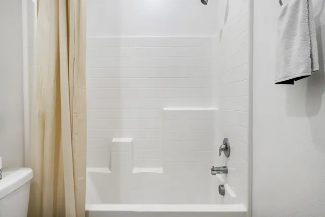 a front view of a house with a yard and potted plants