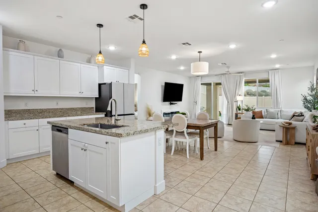 a living room with kitchen island furniture and a flat screen tv