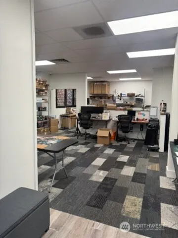 a living room with furniture a rug and a view of kitchen