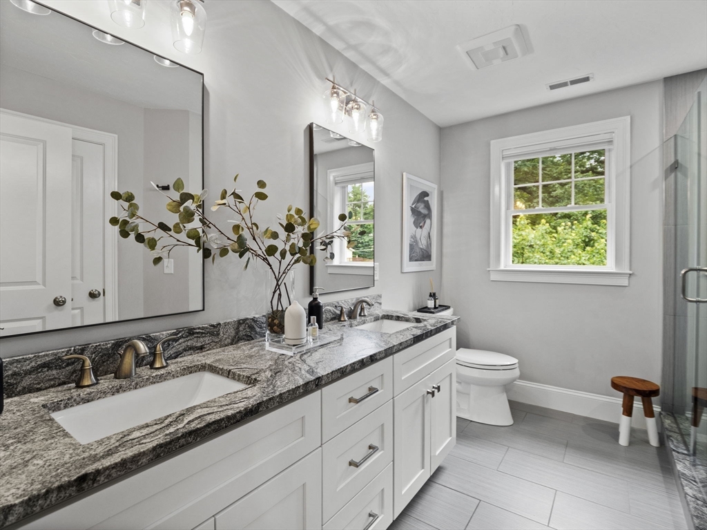 3 Mooney Road Burlington, MA 01803 - Photo 24 of 34 a bathroom with double vanity sinks a mirror and a toilet