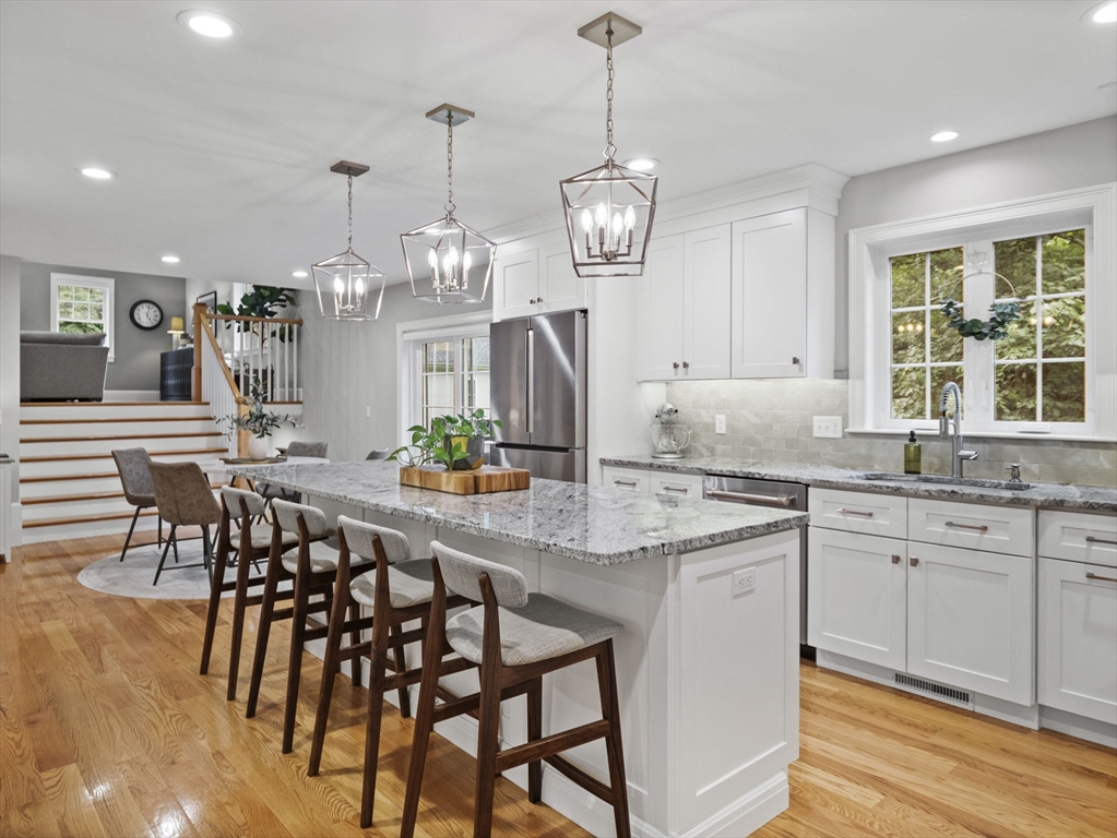 3 Mooney Road Burlington, MA 01803 - Photo 7 of 34 a large kitchen with granite countertop stools a sink a counter space and stainless steel appliances