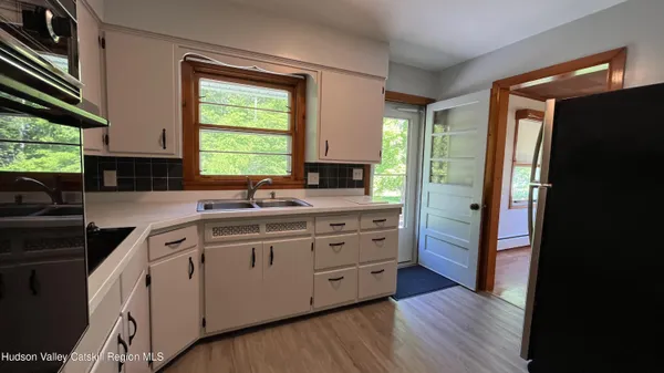 a kitchen with stainless steel appliances a sink cabinets and a window