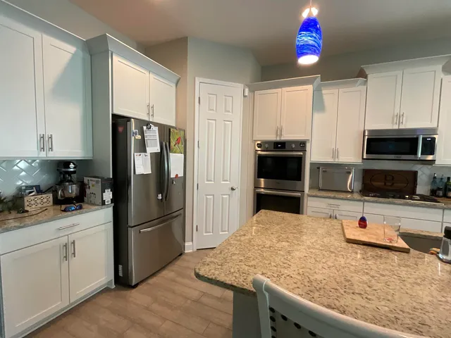 a kitchen with stainless steel appliances granite countertop a stove a sink and a microwave