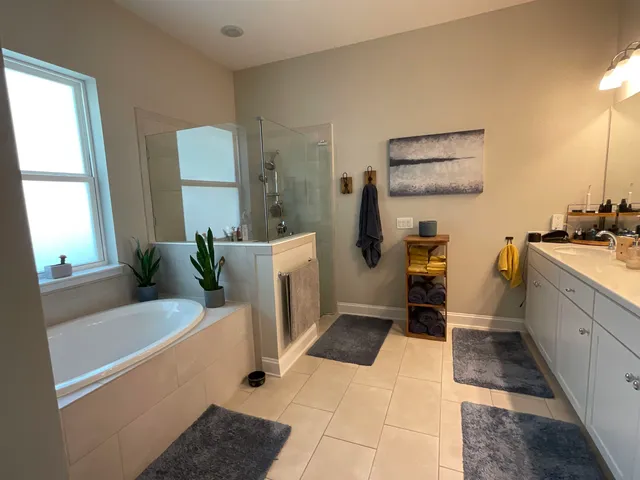 a spacious bedroom with a bed and a flat screen tv