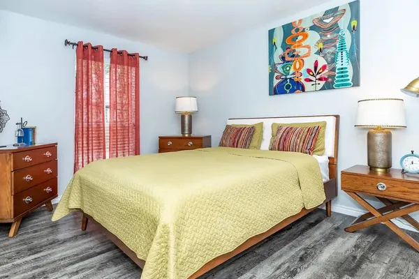 a bedroom with a bed and painting on the wall