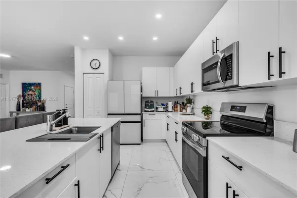 a kitchen with cabinets stainless steel appliances and a sink