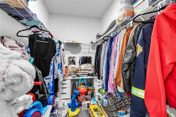 a view of walk in closet with clothes and shoes