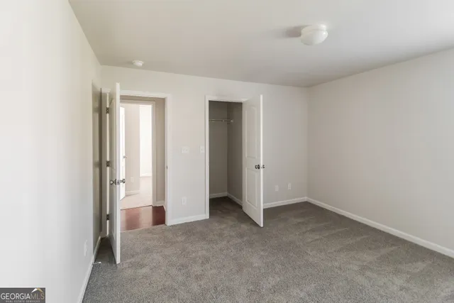 an empty room with windows and closet