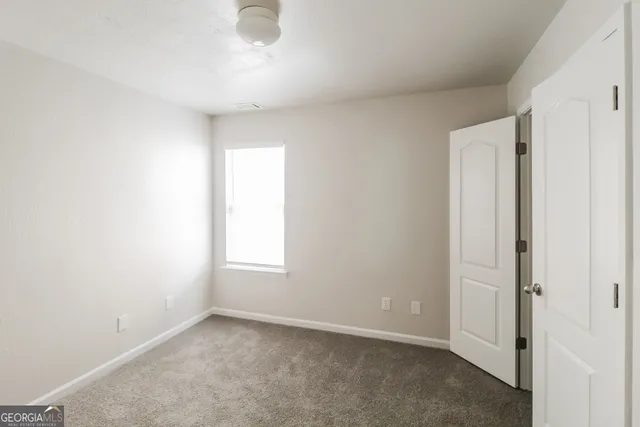 an empty room with windows and closet
