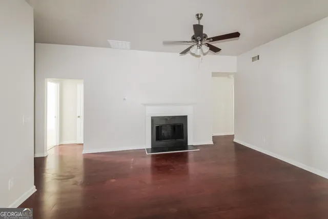 a view of empty room with wooden floor and fireplace