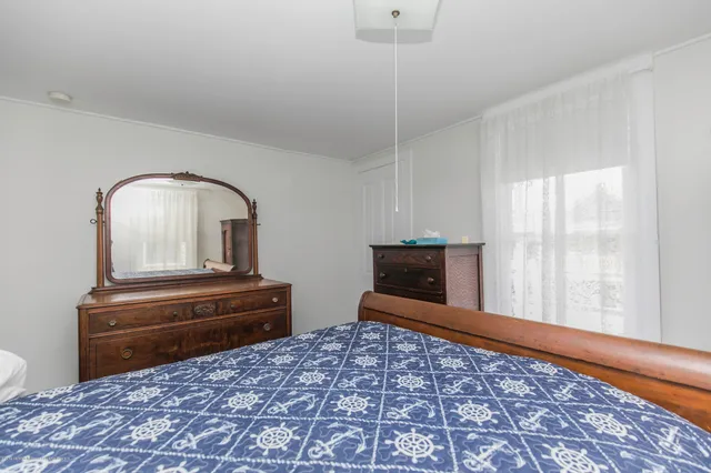 a view of a bedroom with a bed and wooden floor