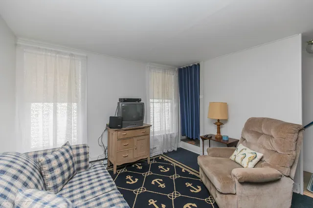 a living room with furniture a flat screen tv and a window
