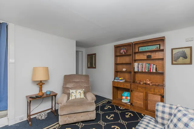 a living room with furniture a rug and a lamp