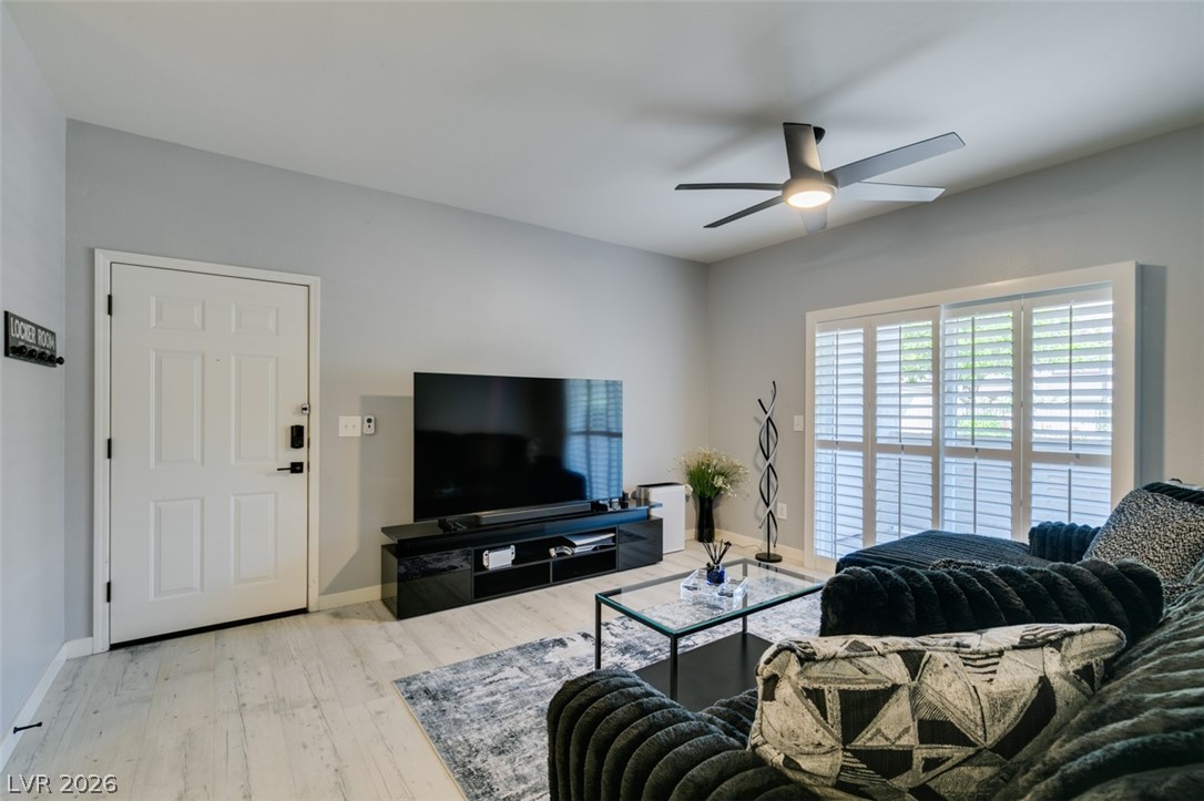 7255 West Sunset Road, Unit 1103 Las Vegas, NV 89113 - Photo 13 of 35 Modern living area with light wood flooring and a refreshing ceiling fan for comfort.