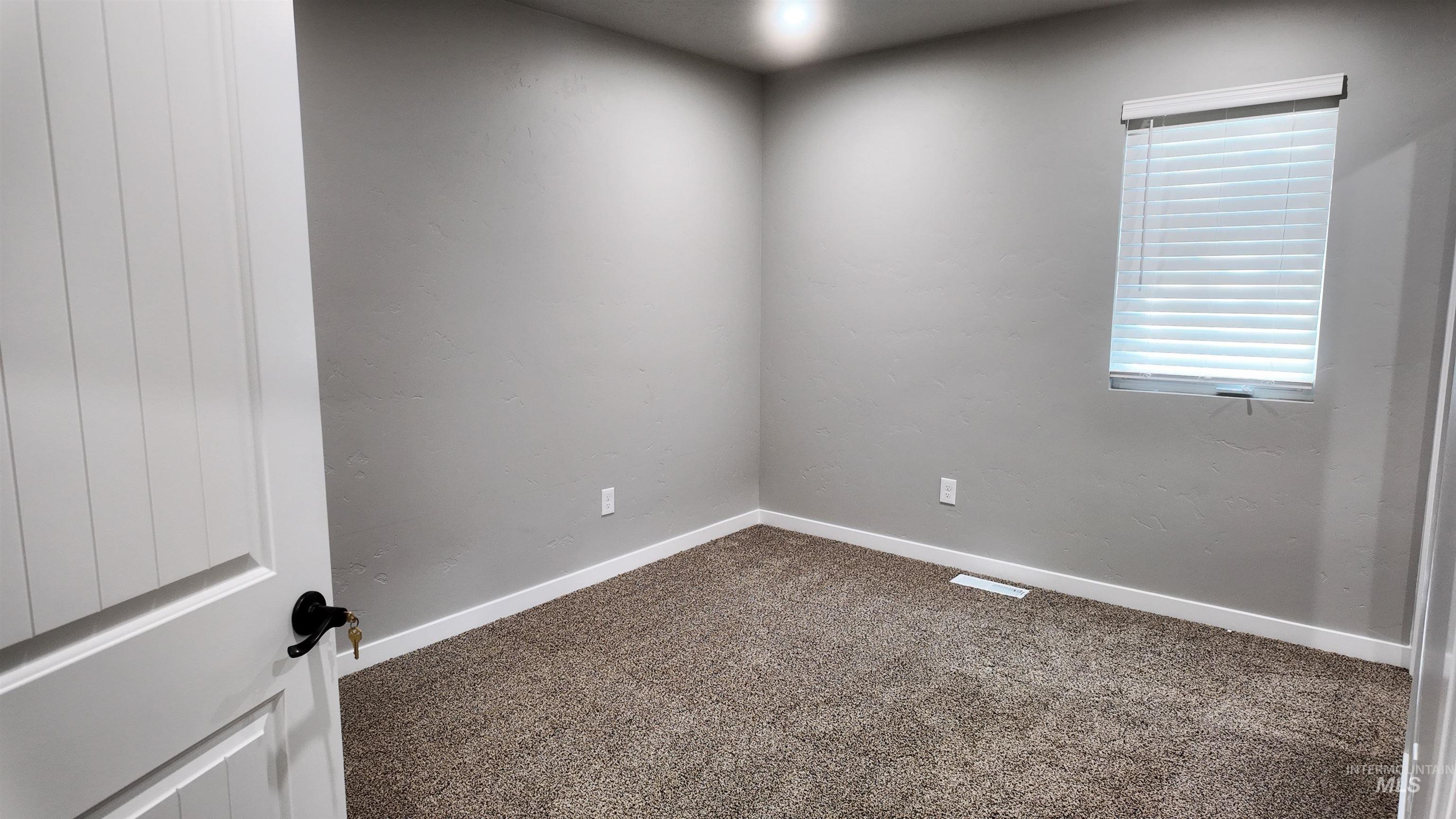 5850 Lockett Road Huntington, OR 97907 - Photo 23 of 49 Empty room with dark carpet and baseboards