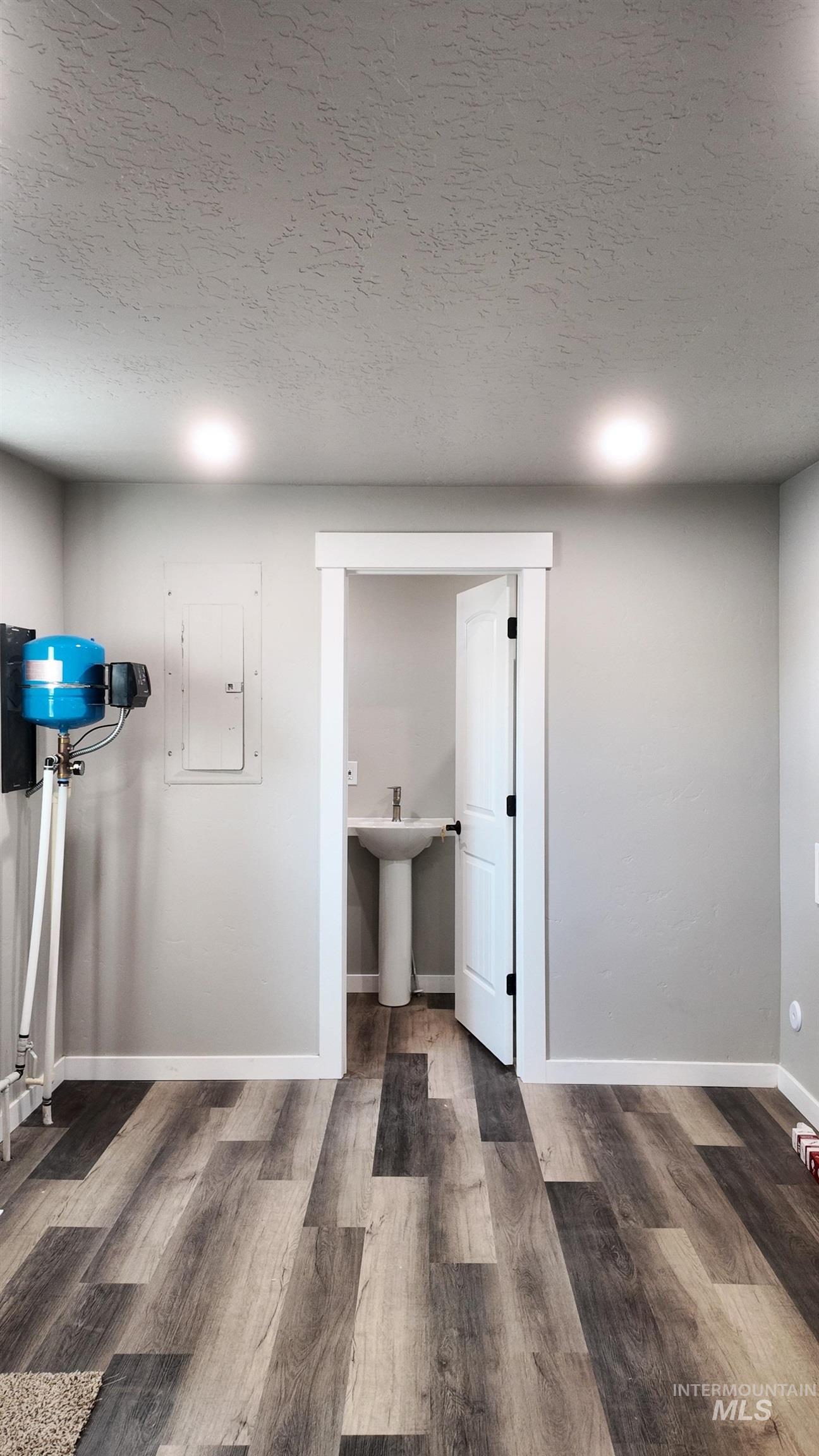 5850 Lockett Road Huntington, OR 97907 - Photo 31 of 49 Basement featuring a textured ceiling, electric panel, and wood finished floors