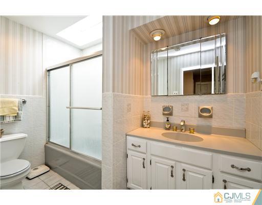 14 Warwick Road Edison, NJ 08820 - Photo 13 of 18 a bathroom with a sink a toilet a mirror and shower