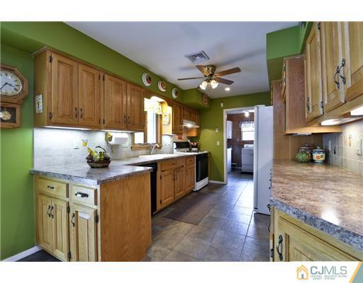 14 Warwick Road Edison, NJ 08820 - Photo 6 of 18 a kitchen with kitchen island granite countertop a sink cabinets and stainless steel appliances