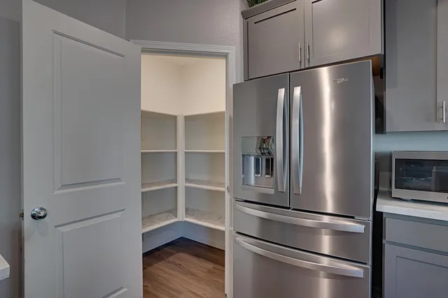 a metallic refrigerator freezer sitting in a kitchen
