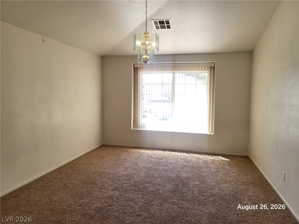 994 Broken Reed Court Henderson, NV 89015 - Photo 12 of 18 Natural light fills this versatile room featuring plush carpeting and a classic chandelier fixture.
