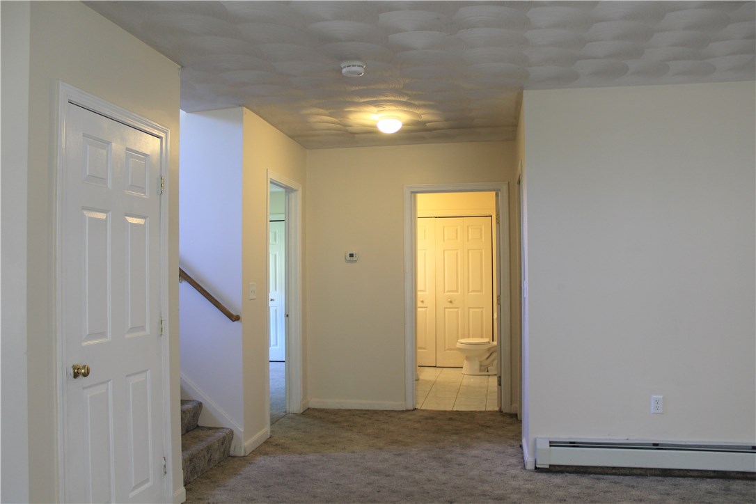 268 Asylum Street Woonsocket, RI 02895 - Photo 15 of 21 Lower level view showing 3rd Bedroom doorway and straight ahead a full bath. Storage closet to the left and stairway leading up to the main floor.