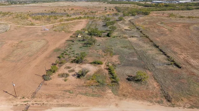 a view of a dry yard with wooden fence