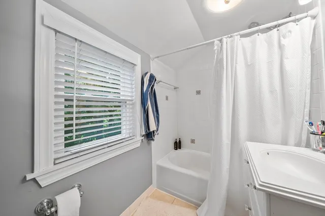 a view of a patio with table and chairs with plants and large trees