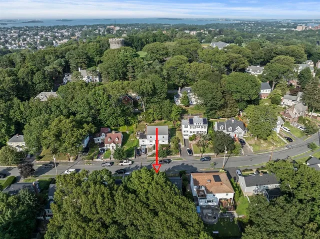 an aerial view of residential houses with outdoor space and trees