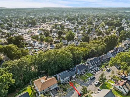 an aerial view of residential houses with outdoor space and trees