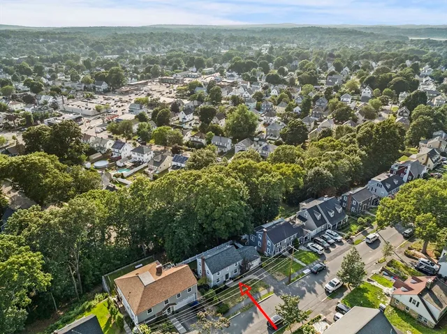 an aerial view of residential houses with outdoor space and trees
