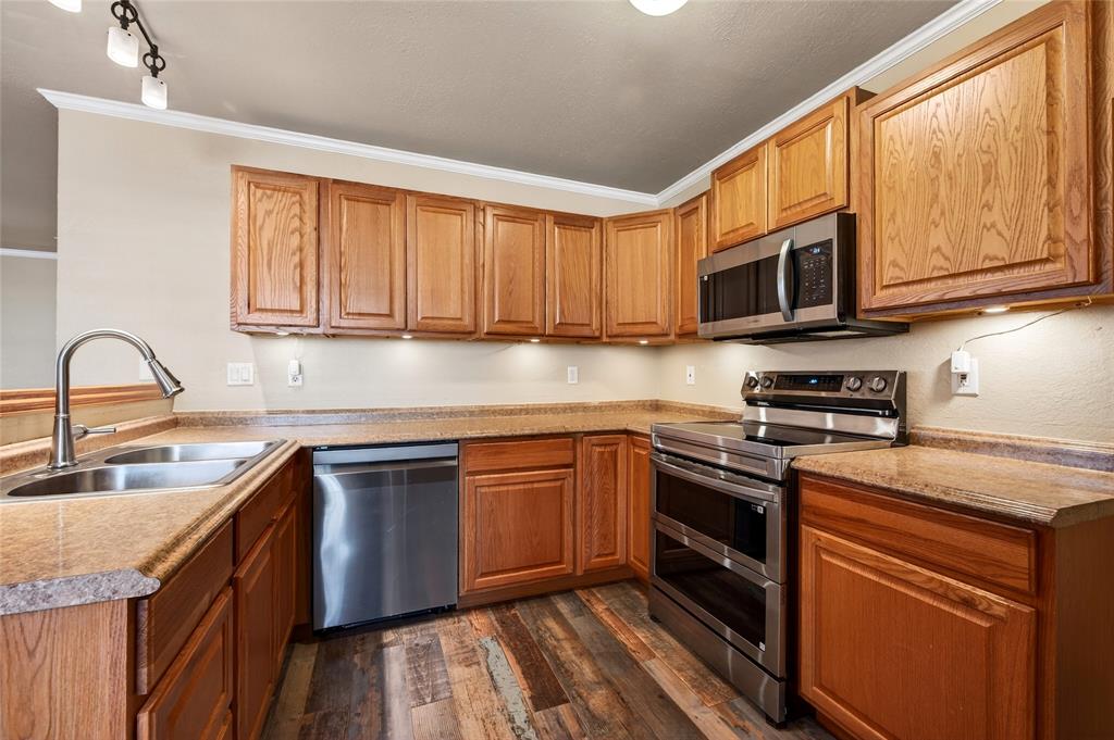 905 Calder Street Howe, TX 75459 - Photo 13 of 35 a kitchen with stainless steel appliances granite countertop a sink stove microwave and refrigerator
