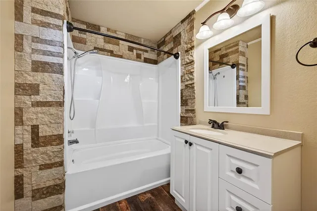a bathroom with a tub a sink and a mirror