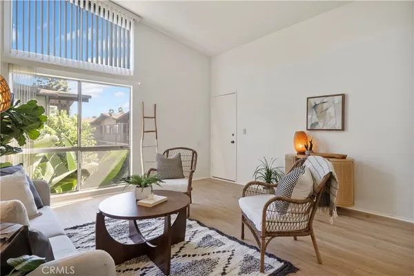 a living room with furniture a window and a potted plant