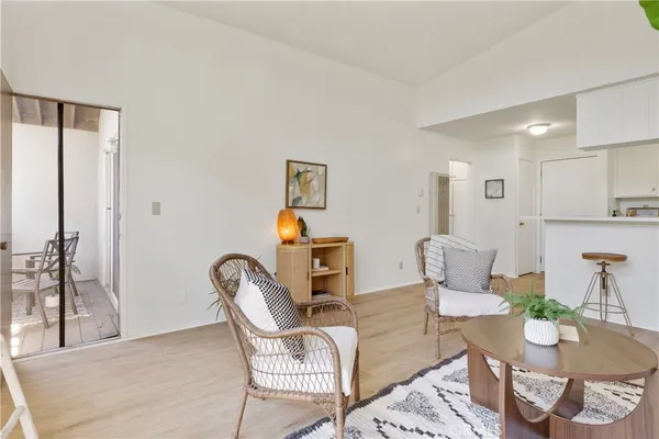 a living room with a couch and a dining table with wooden floor