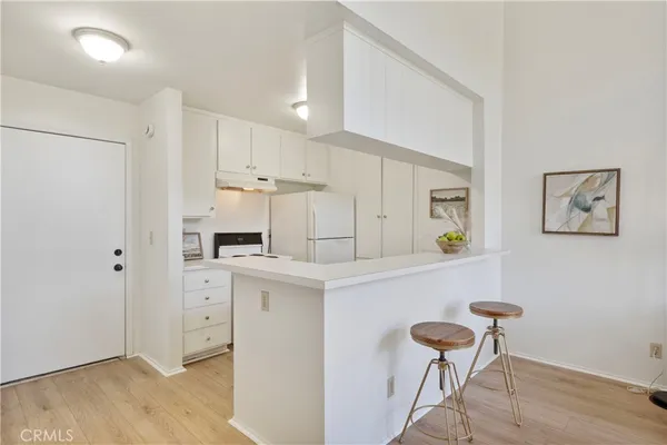a kitchen with stainless steel appliances cabinets a wooden floor and a sink
