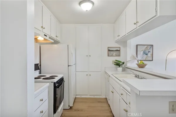 a kitchen with white cabinets and appliances