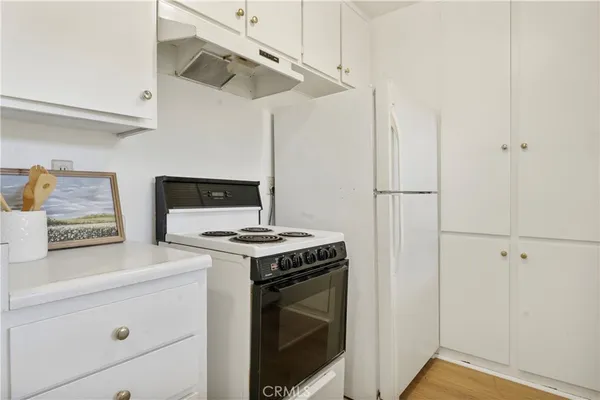 a kitchen with a stove and white cabinets