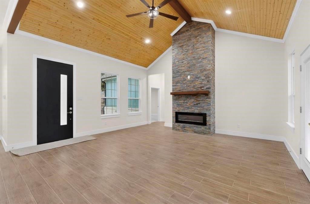 335 Cross Tie Ranch Road Trinidad, TX 75163 - Photo 5 of 30 Spacious interior featuring a vaulted wood-plank ceiling, wood-finish flooring, and a stone-clad fireplace with an electric insert