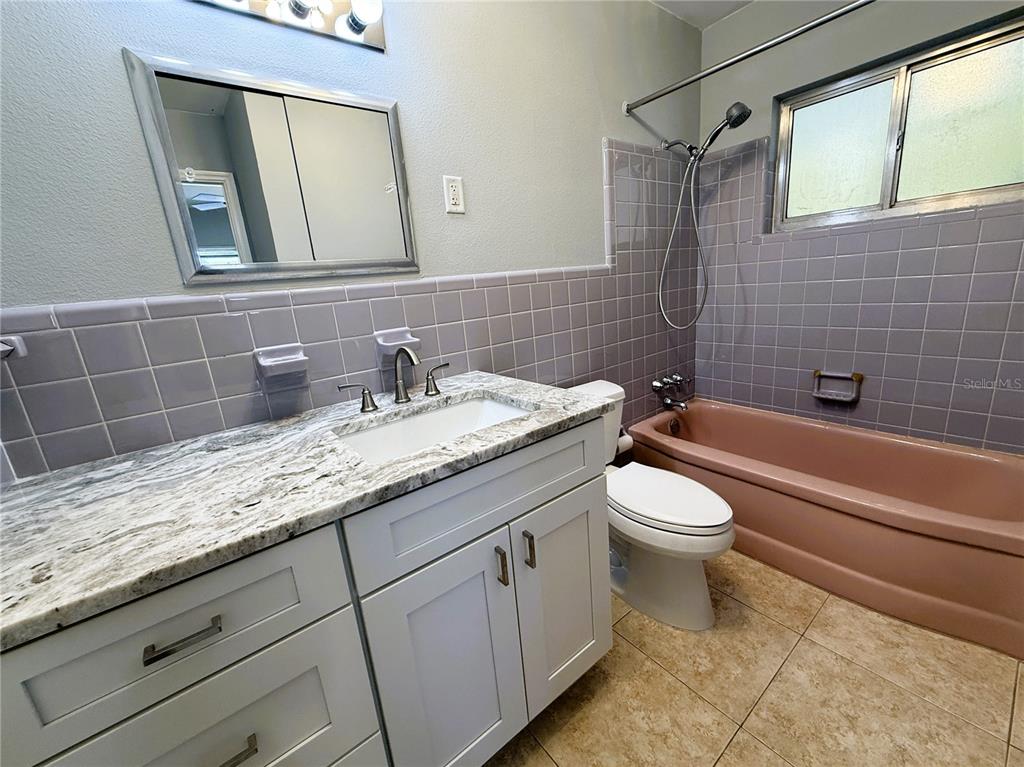 500 140th Avenue East Madeira Beach, FL 33708 - Photo 19 of 30 a bathroom with a granite countertop toilet sink and mirror