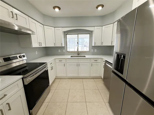 a kitchen with a stove sink and cabinets