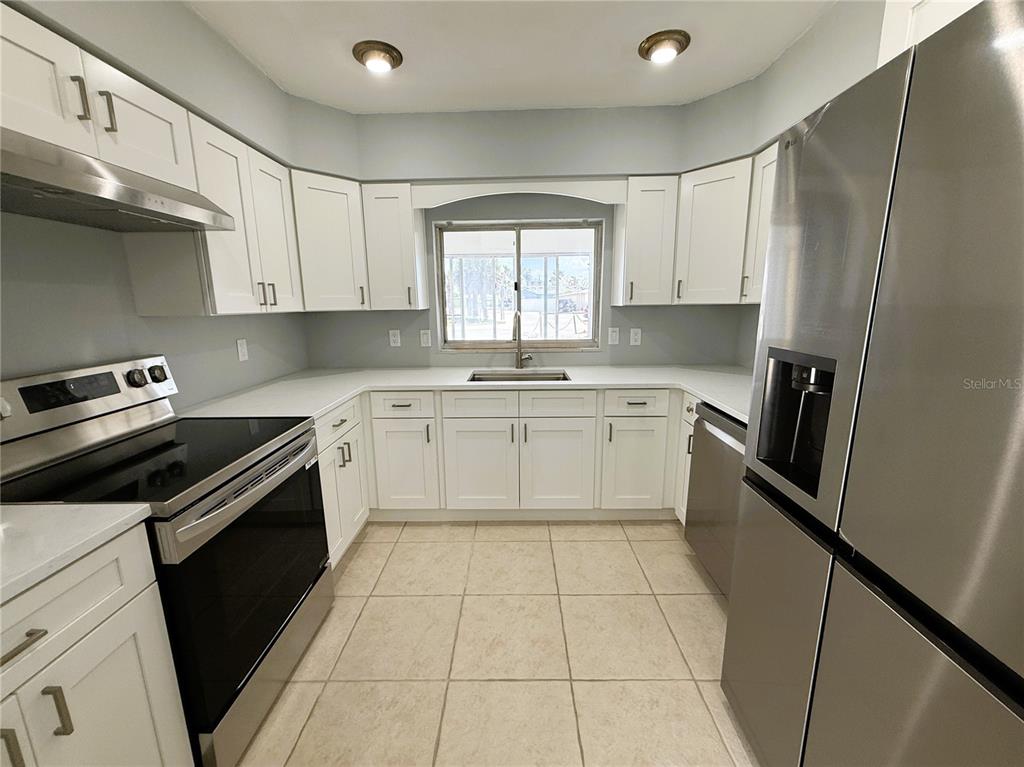 500 140th Avenue East Madeira Beach, FL 33708 - Photo 4 of 30 a kitchen with a stove sink and cabinets