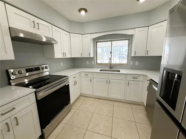 a kitchen with a stove sink and cabinets