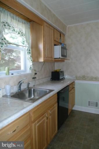 1822 Forrest Road Parkville, MD 21234 - Photo 4 of 21 a kitchen with sink a microwave and cabinets