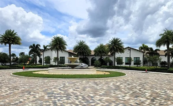 a front view of a house with garden and trees