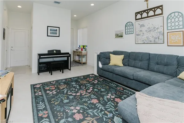 a living room with furniture and a piano