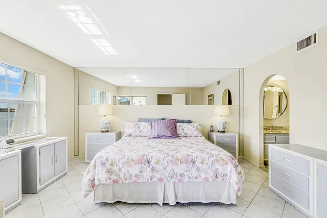 a bedroom with a large bed and a view of kitchen