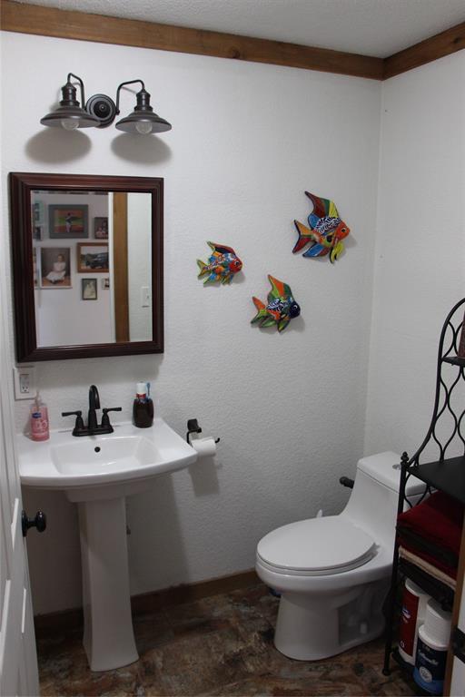 800 Griffin Road Albany, TX 76430 - Photo 10 of 15 a bathroom with a toilet sink and mirror
