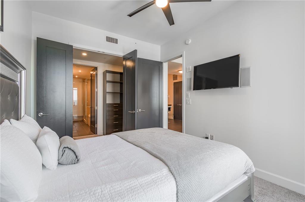 1820 Peachtree Road Northwest, Unit 1111 Atlanta, GA 30309 - Photo 15 of 41 a bedroom with a bed and a flat tv screen