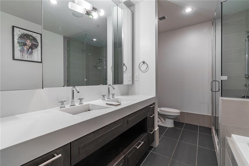 1820 Peachtree Road Northwest, Unit 1111 Atlanta, GA 30309 - Photo 18 of 41 a bathroom with a double vanity sink toilet and a mirror